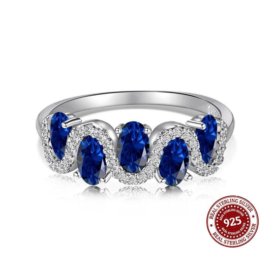 Silver ring with blue gemstones on a white background, featuring a 'Real Sterling Silver 925' stamp.