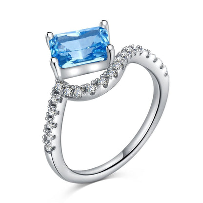Silver ring with blue rectangle gemstone and small diamonds.

